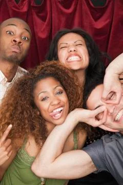 Friends making silly faces in photo booth Stock Photos