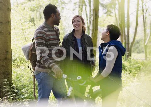 Friends with mountain bike hiking and talking in woods Stock Photos