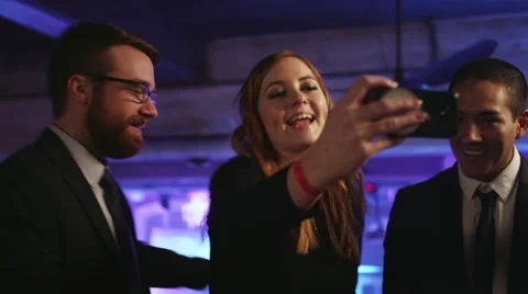 Friends in a nightclub taking selfies with a cell phone Stock Footage