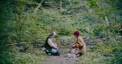 Friends Packing Bags While Crouching In Forest Stock Footage 252019182