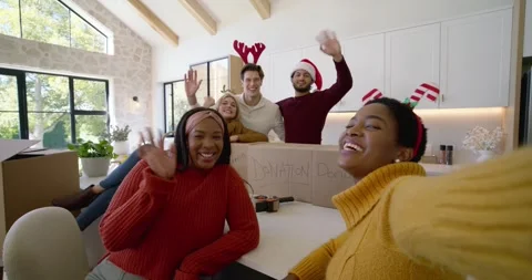 Friends packing DONATION boxes on kitchen island as woman in sweater filming on Stock Footage 344459852