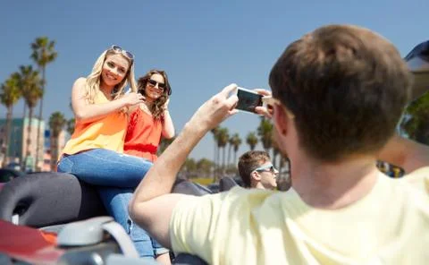 Friends photographing in car over venice beach Stock Photos