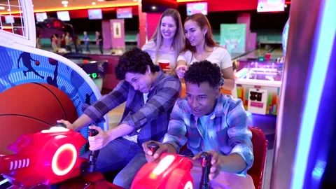 Friends playing arcade motorcycle racing game Stock Footage 308262259