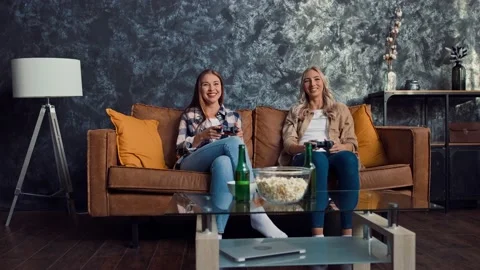 Friends Playing Console Games and Chatting at Home. Friends at Couch. Gamers at Stock Footage 217890548