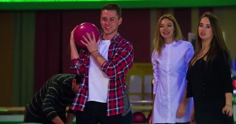 Friends playing fun at bowling 4k video. Man holds ball. Players talks laughs Stock Footage 72220722