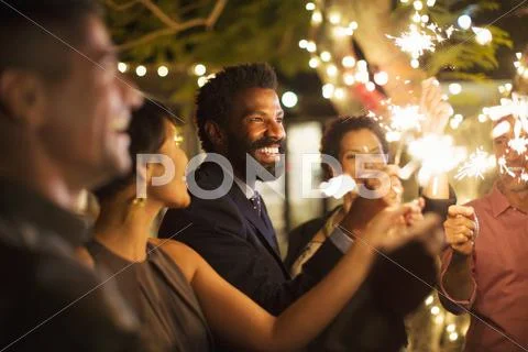 Friends playing with sparklers at party Stock-Fotos
