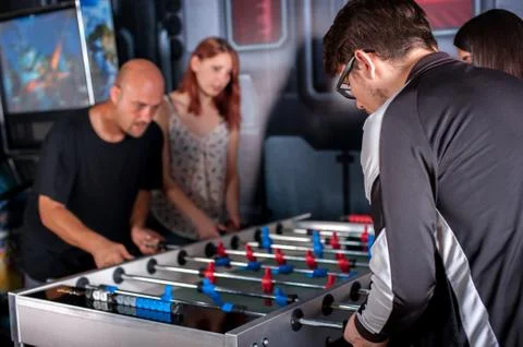 Friends playing table foosball Stock Photos