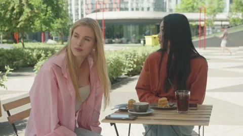 Friends Pointing And Talking While Enjoying Coffee At Outdoor Cafe Stock Footage 313843756