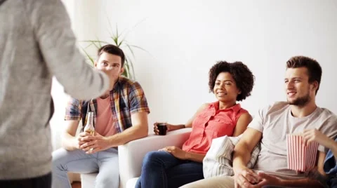 Friends with popcorn and drinks talking at home Stock Footage