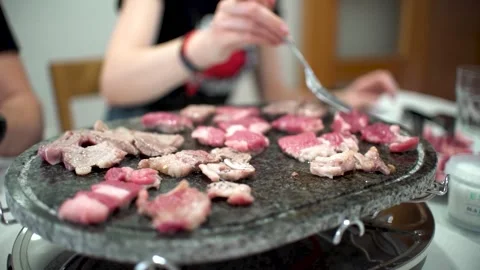 Friends preparing their own meat at hot stone. Stock Footage 241413186