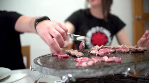 Friends preparing their own meat at hot stone. Vídeos de archivo 241413307