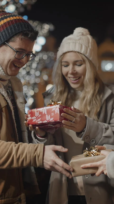 Friends presenting gift to each other outdoor at decorated illuminated Video stock 289166187