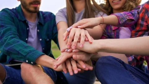 Friends put their hands together and throw them up.  Stock Footage 75765741