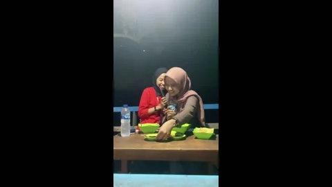 Friends react to unexpected lizard in food bowl in Maros, Indonesia Stock Footage 251190292