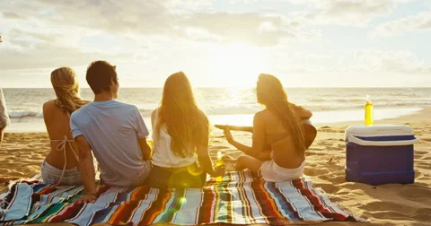 Friends Relaxing on the Beach at Sunset Stock Footage 65878155