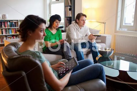 Friends Relaxing Together In Living Room