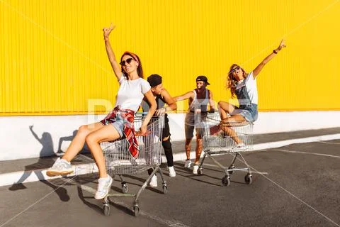 Friends ride on carts, near the supermarket, a great pastime, a group of youn Stock Photos