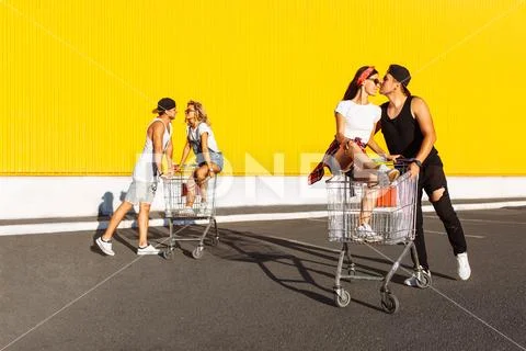 Friends ride on carts, near the supermarket, a great pastime, a group of youn Stock Photos