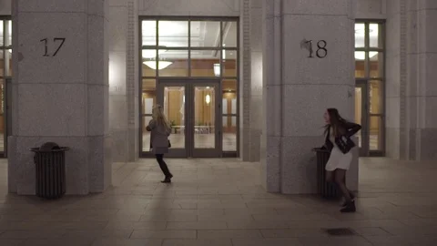Friends Run Around Large Columns In Front Of Building At Night Stock Footage 73309606