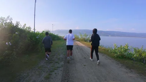 Friends Running Along a Scenic Path by the Water Stock Footage 303627006