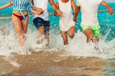 Friends running in the sea water and having fun Stock Photos