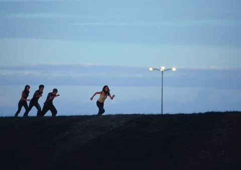 Friends running at sunset Fotos de archivo