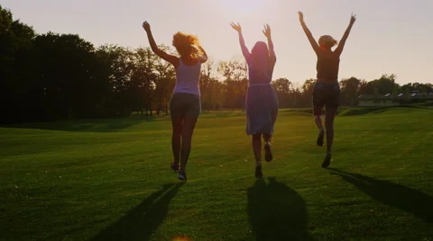 Friends running towards the sun. Group of young people joyfully running through Stock Footage 65521795