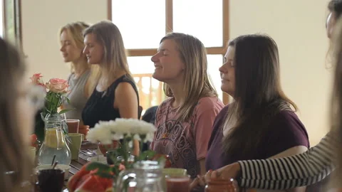 Friends saying grace before vegetable dinner at home in kitchen Stock Footage 94378603
