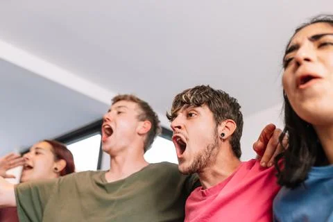 Friends screaming with joy watching e-sports on TV after their team's victory Stock Photos