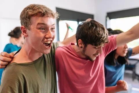Friends screaming with joy watching e-sports on TV after their team's victory Stock Photos