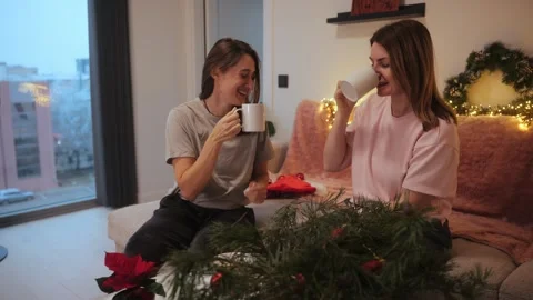Friends share drinks while talking and enjoying a cozy indoor setting during Stock Footage 341507487