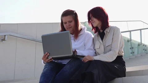 Friends share knowledge on laptop while enjoying a sunny day outdoors Vídeos de archivo 295274717