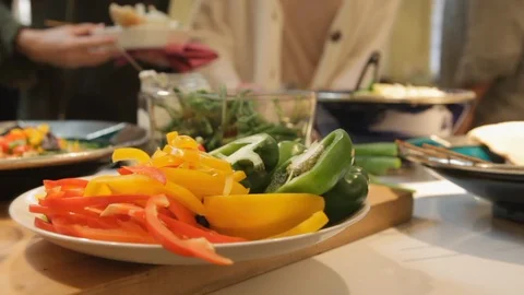 Friends sharing food from a dinner table. Preparing food in the kitchen. Stock Footage 106078142