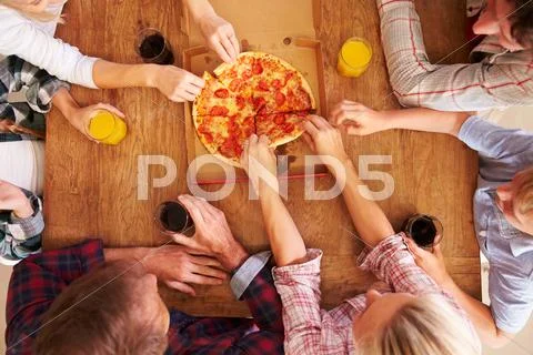 Friends sharing a pizza together, overhead view Stock Photos