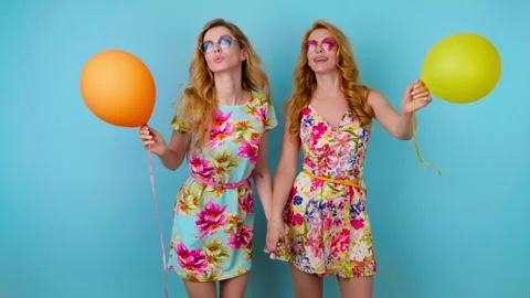Friends sister dancing having fun, fashionable woman in floral dress with balloo Stock Footage 256311589