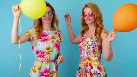 Friends sister dancing having fun, fashionable woman in floral dress with balloo Stock Footage 256311769