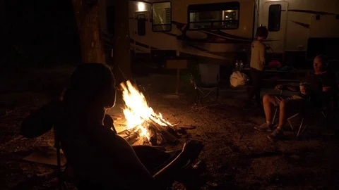 Friends Sit Around a Campfire in Front of 5th Wheel Trailer Stock Footage 80534808