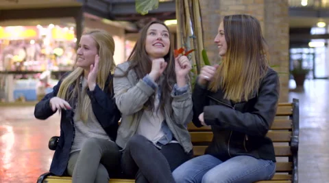 Friends Sit On Bench And Practice Funny Dance Moves Together, They Laugh Video stock 63360104