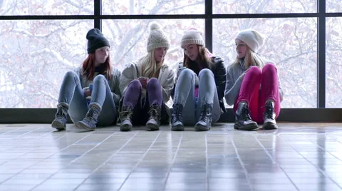 Friends Sit Inside On A Snowy Winter Day, They Play With Their Smartphones Vídeos de archivo 47008415