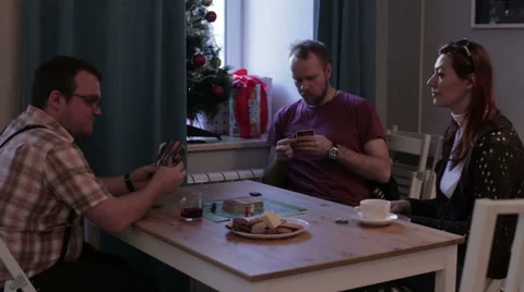 Friends sit at the table and play cards Stock Footage 58783914