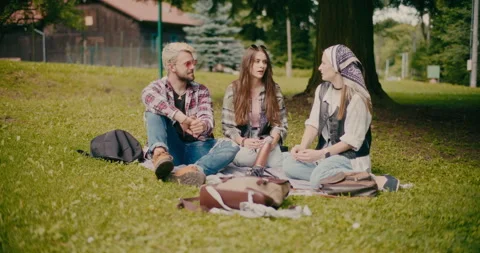 Friends Sitting And Talking On Grass At Park Stock Footage 251892302