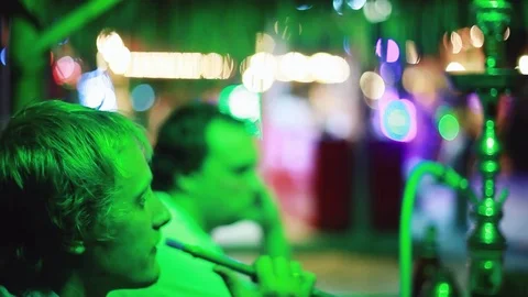 Friends sitting in beach Hookah Bar, Man smokes. 1920x1080 Stock Footage 80230296