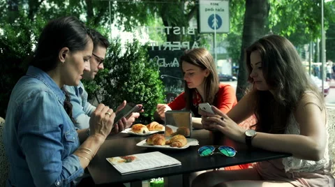 Friends sitting in the cafe and using mobile phones, steadycam shot Stock Footage 52720515