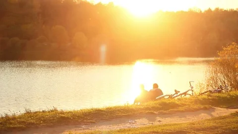 Friends-sitting-river-sunset-2 Stock-Footage 96718156