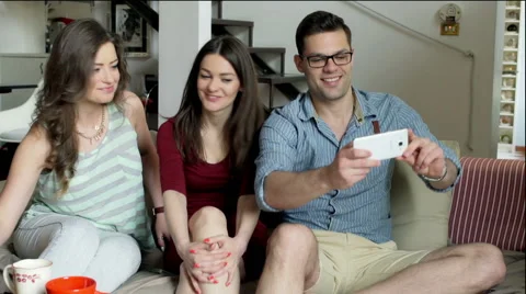 Friends sitting on the sofa and doing photo on smartphone Stock-Footage 54086604
