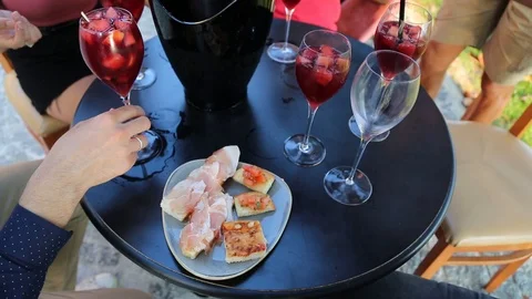 Friends sitting at the table in the bar drinking sangria with aperitif Stock Footage 120031326