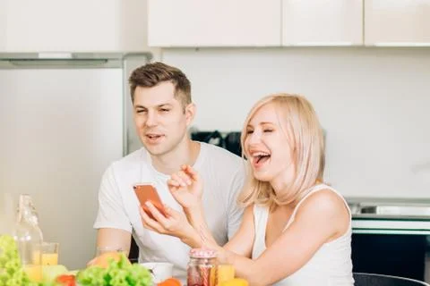 Friends sitting at table in kitchen Stock Photos