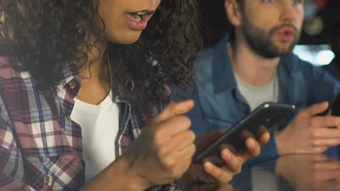 Friends with smartphones cheering for sports team victory in bar, betting online Stock Footage
