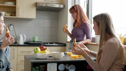 Friends snacking on chocolate croissants in the dorm room kitchen Stock Footage 223955792