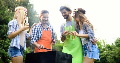 Friends spending time in nature and having barbecue Stock Photos